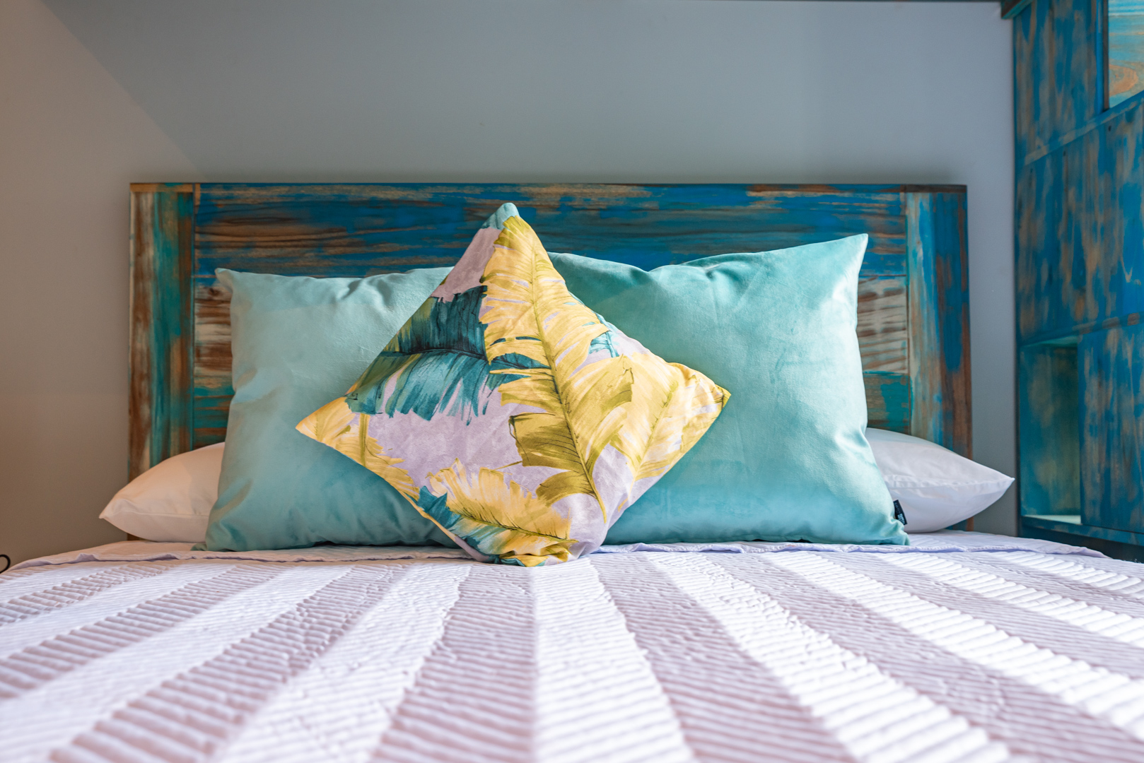 Queen bed with tropical pillows in Tower Suite 1 at Villa Costa Vida
