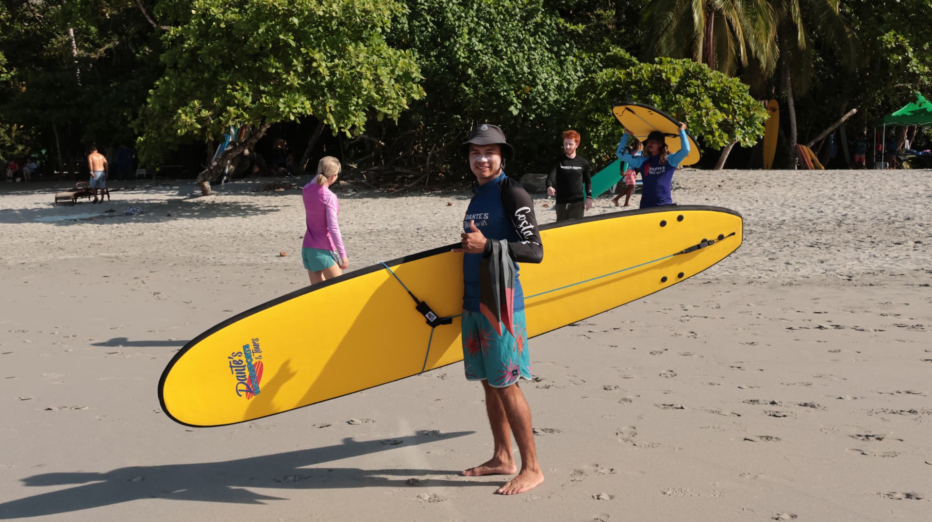 Dante's surf instructor with a yellow board on Playa Espadilla