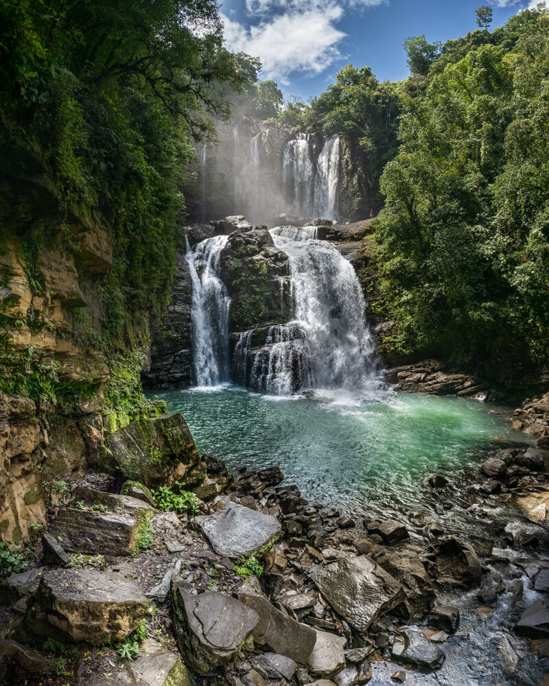 Waterfall cascading into a natural pool in the Costa Rican rainforest